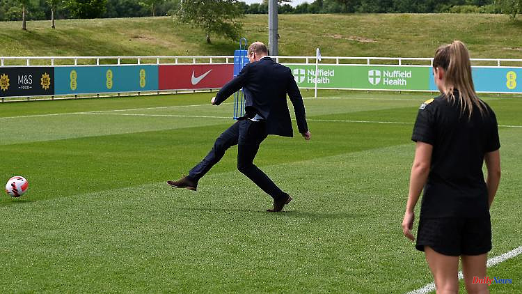 Kick it like William: Prince William plays football - in a suit